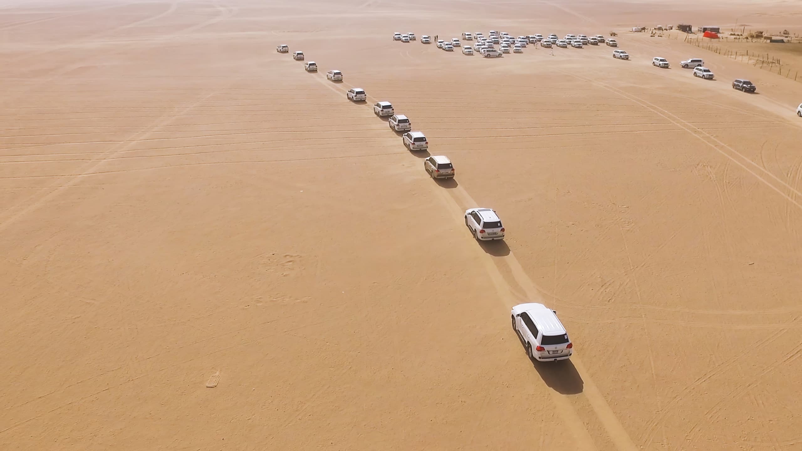 4x4 convoy crossing the sand dunes of Abu Dhabi, photographed from above